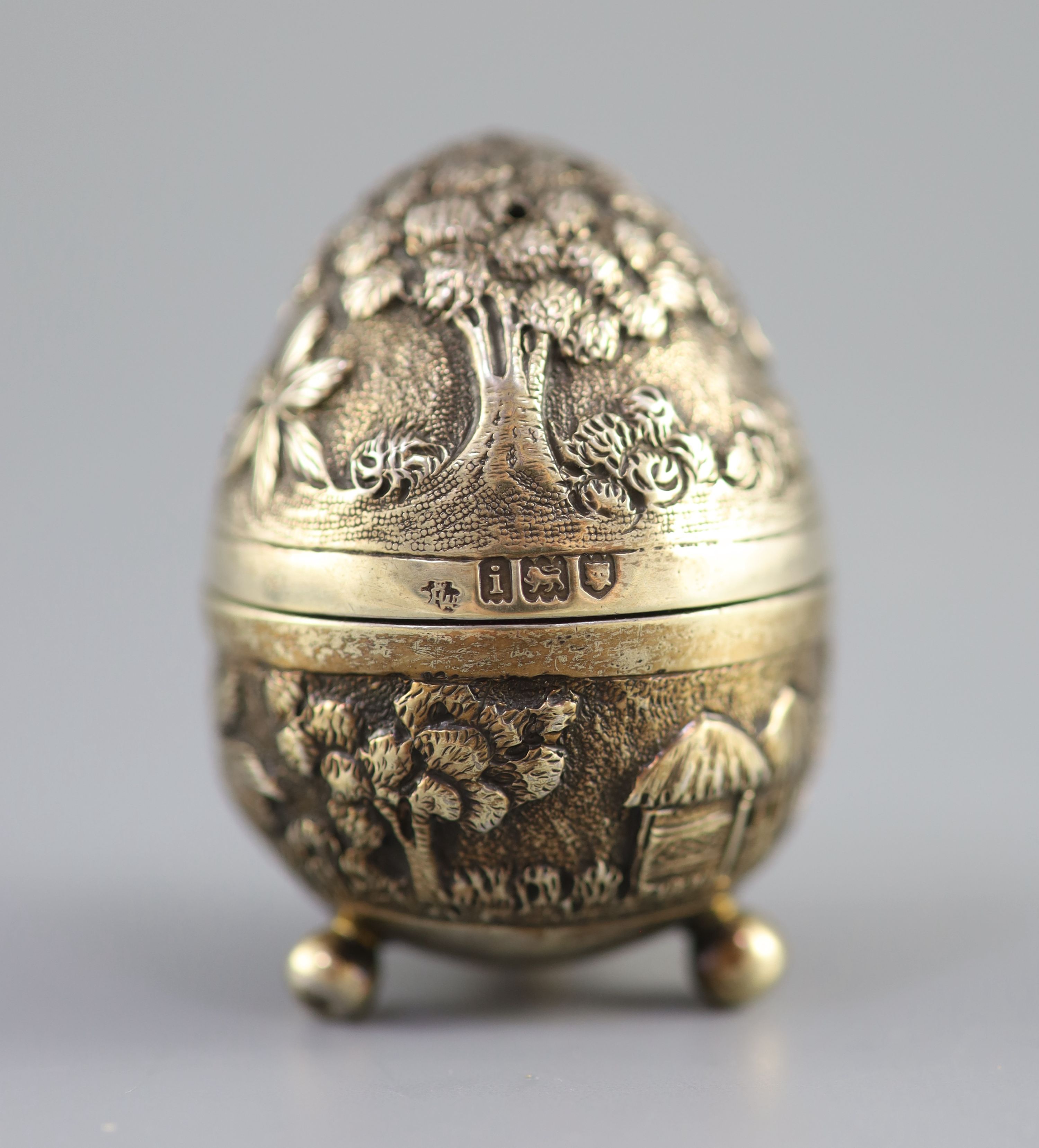 A graduated pair of Edwardian novelty silver gilt condiments, modelled as eggs, with bird's nest interior including two 'marbled' eggs